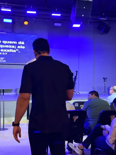 Ricardo Fiorillo diante do telão com o versículo de 1 Samuel 2:7, e participantes tomando notas